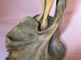 a statue of a woman holding a flower in her hand