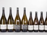 six bottles of wine are lined up in a row on a white surface