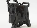 a black cow figurine sitting on a white surface