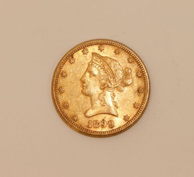 a close up of a gold coin with a woman ' s head on it