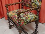 a chair with a colorful upholstered upholstered seat on a tile floor