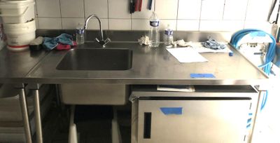 une cuisine équipée d'un évier et d'un lave-vaisselle