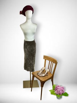 a mannequin sitting on a chair next to a wooden chair
