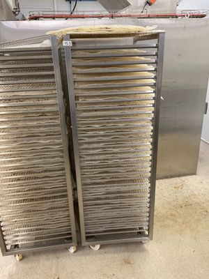 deux étagères remplies de provisions posées par terre dans la cuisine