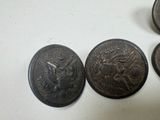 four antique military buttons sitting on top of a white surface
