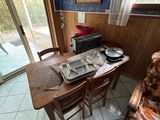 une table et des chaises dans une pièce dotée d'une porte-fenêtre coulissante