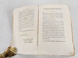 an open book with a tassel on top of it