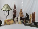 a lot of statues and a lamp on a table