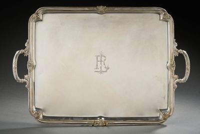 un plateau en argent muni de poignées, posé sur une table
