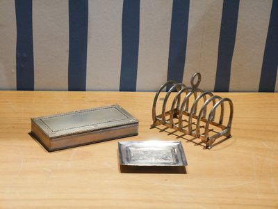 une assiette en argent et un porte-cartes en argent posés sur une table en bois
