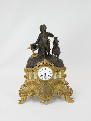 une petite horloge surmontée d'une statue