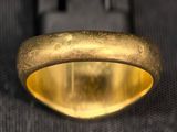 a close up of a gold ring on a black surface