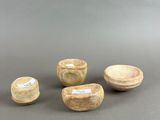 three small wooden bowls and a small bowl on a gray surface