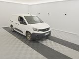 une camionnette blanche garée dans une pièce au sol en damier