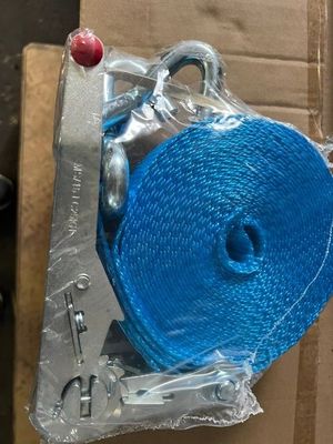 un rouleau de corde bleue emballé dans du plastique, posé sur une boîte