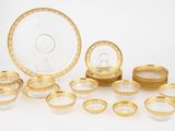 un assortiment d'assiettes et de plats dorés et blancs disposés sur un fond blanc