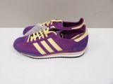 purple and yellow adidas sneakers on a white surface