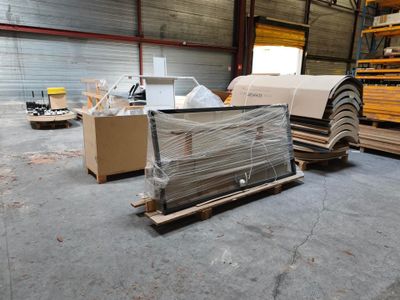 un gros tas de bois dans un entrepôt rempli de palettes et de cartons