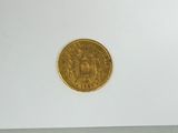 a close up of a gold coin on a white surface