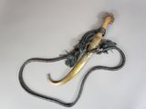 un serpent enroulé autour d'une longue corne sur une surface blanche