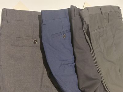 three pairs of men ' s pants are lined up in a row
