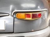 a close up of a car ' s tail light with a brick wall in the background