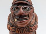 a wooden figurine of a man with a hat on his head
