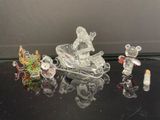 plusieurs figurines en verre représentant des souris et un traîneau, posées sur une table