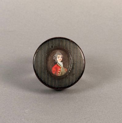 Un portrait miniature représentant un homme vêtu d'un manteau rouge est présenté dans un cadre noir et blanc.