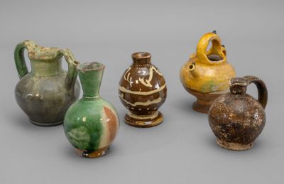 several vases are lined up in a row on a gray surface