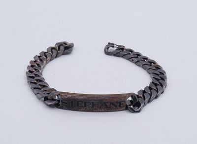 Le bracelet est en bois et comporte un fermoir en métal.