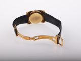 an image of a gold and black watch on a white surface