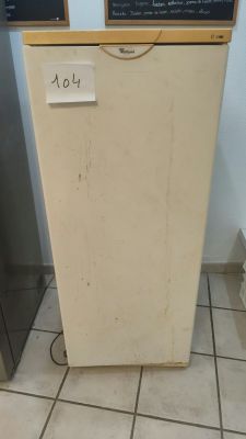 a small refrigerator with a chalk board on top of it