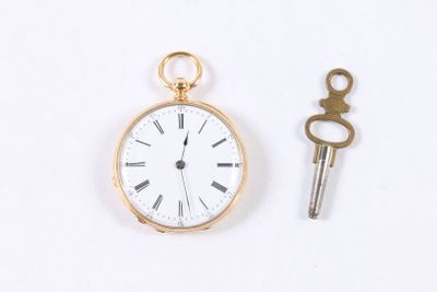 une montre de poche en or et une clé posées sur une surface blanche