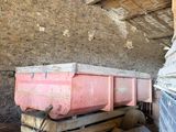 a pink box sitting on top of a trailer in a barn