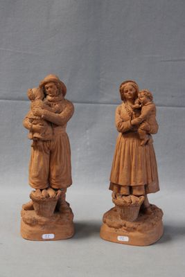 two wooden figurines of a woman holding a baby and a child