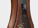 a wooden grandfather clock with a glass case on top of it