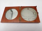 an old wooden clock with a mirror on top of it