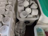 many cups and containers that are sitting on a table
