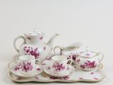 a tea set on a tray with pink flowers on it