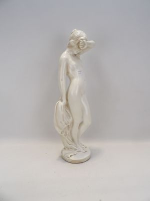 statue d'une femme debout sur un socle, les mains dans les poches