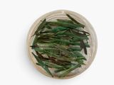 dried green beans in a glass bowl on a white surface
