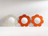 three flower shaped mirrors sitting on top of a white surface