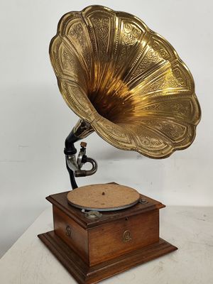 un vieux gramophone posé sur un socle en bois, avec un fond blanc