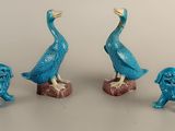three blue figurines of birds and a dog on a table