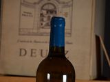 a bottle of wine sitting on a table next to a book