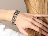 blonde woman with long hair in a white shirt and bracelets