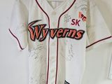 Le maillot de baseball est accroché au mur de la pièce.