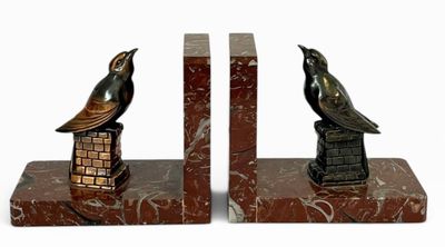 deux serre-livres surmontés d'un oiseau, sur fond blanc