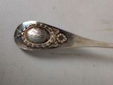 a spoon that has a silver spoon with a picture on it